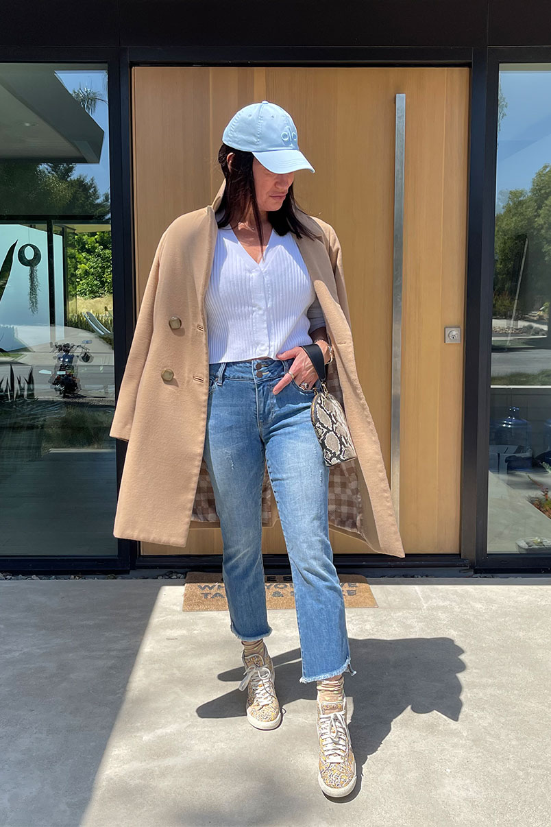 Kat Woodside, Chief Design Officer models her outfit of the day featuring the Slim Rib Cardigan in Brite White, High-Low Crop in Skip Wash, beige trench coat, accessories and sneakers.