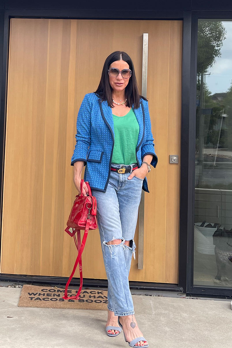 Kat Woodside, Chief Design Officer models her outfit of the day featuring the Scholarship Blazer in Blue Check, Park Cami in Verdant, 100% Boyfriend in Sandstorm Wash, statement accessories and sandals